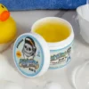 Otwarta pomada Suavecito Kid’s do stylizacji włosów dzieci z widoczną żelową konsystencją, ustawiona na blacie obok akcesoriów łazienkowych